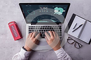 Top view of businessman using laptop computer with statistics data on a screen.