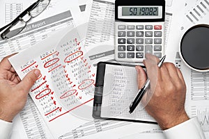 Top view of businessman working with financial statements. Modern black office desk with notebook, pencil and a lot of things.