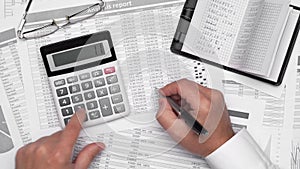 Top view of businessman working with financial statements. Modern black office desk with notebook, pencil and a lot of things.