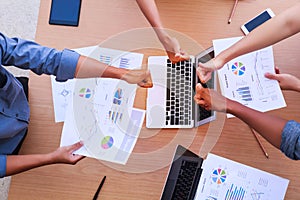 Top view of businessmen and businesswoman thumbs up over table in a meeting with copy space at mobile office. Teamwork, diversity