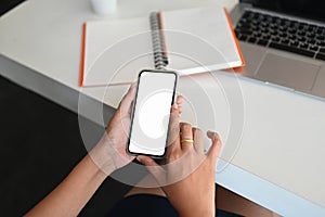 Top view businesswoman hands holding and using smartphone.