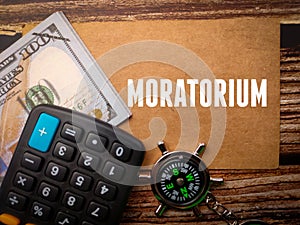 Top view calculator,compass and banknotes with text MORATORIUM