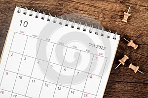 Top view Calendar desk 2022 on October month, The concept of planning and deadline with push pin on wooden table background