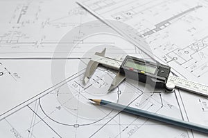 Top view of a caliper measuring tool, pencil and detail drawings.Engineering drawings, metal detail