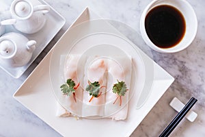 Top view of Cantonese fresh shrimp spring rolls with sour sauce served in white plate on marble top table