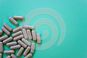 top view capsules of dietary supplements on green background. Layout white soft soluble. copy space. Concept of healthy life,