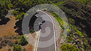 Top view of a car and cyclist rides along a mountain road on Tenerife, Canary Islands, Spain. Way to the Teide volcano