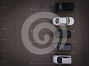 Top view car driving on parking place. Aerial view from above flying drone car moving and standing on parking lot in