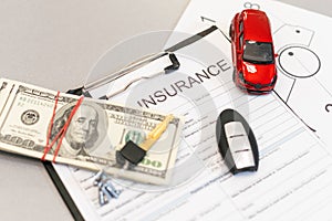 Top view of car insurance claim form with car key and car toy on desk