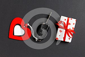 Top view of car key, gift boxes and toy heart on colorful background. Close up of Saint Valentine`s Day concept