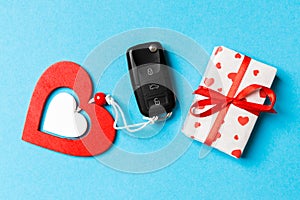 Top view of car key, gift boxes and toy heart on colorful background. Close up of Saint Valentine`s Day concept