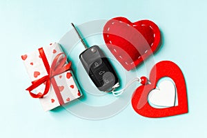 Top view of car key, gift boxes and toy hearts on colorful background. Close up of Saint Valentine`s Day concept