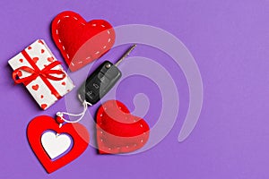 Top view of car key, gift boxes and toy hearts on colorful background. Saint Valentine`s Day concept with copy space