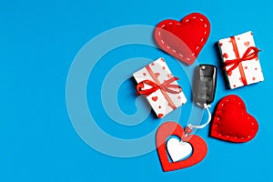 Top view of car key, gift boxes and toy hearts on colorful background. Saint Valentine`s Day concept with copy space