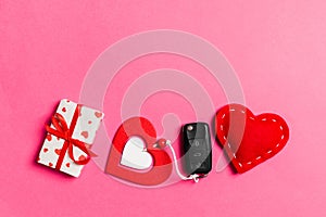 Top view of car key, gift boxes and toy hearts on colorful background. Saint Valentine`s Day concept with copy space