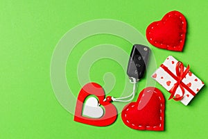 Top view of car key, gift boxes and toy hearts on colorful background. Saint Valentine`s Day concept with copy space