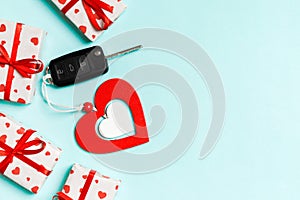 Top view of car key, gift boxes and wooden heart on colorful background. Saint Valentine`s Day concept with copy space