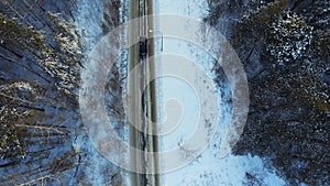 Top view of the car riding in the woods. Footage. The car goes on a winter road in the woods