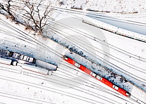 Top view of cargo trains and passanger diesel multiple unit - DMU. Aerial top view from flying drone of snow covered freight
