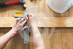 Top view carpenter measuring wood panel before build wooden furniture.