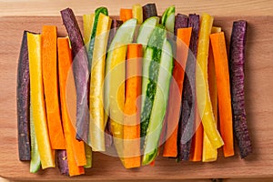 top view of carrots and cucumbers vegetables julienned for snack on wooden board, concept of vegetarian appetizer