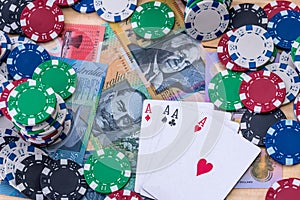 Top view of casino chips with four aces and australian dollars