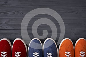 Top view of casual colorful suede trainers on grey wooden planks