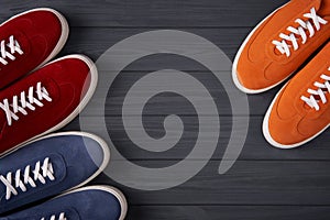 Top view of casual colorful suede trainers on grey wooden planks