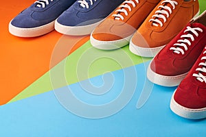 Top view of casual colorful suede trainers on grey wooden planks