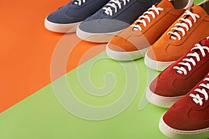 Top view of casual colorful suede trainers on grey wooden planks