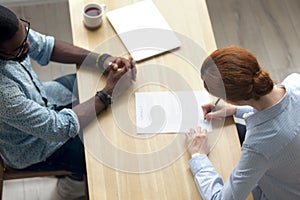 Top view of caucasian woman signing official document at meeting