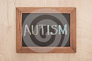 Top view of chalkboard with autism lettering on wooden table.