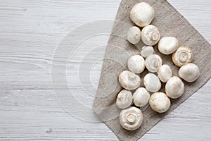 Top view, champignon mushrooms over white wooden background. From above, overhead.