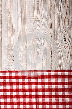 Top view of checkered tablecloth on white wooden table.