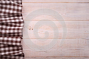 Top view of checkered tablecloth on white wooden table.