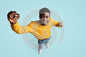 Top view of cheerful black guy gesturing on blue