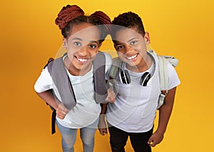 Top view of cheerful black pupils going to school