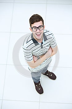 Top view of cheerful young man in casuel wear keeping arms cross