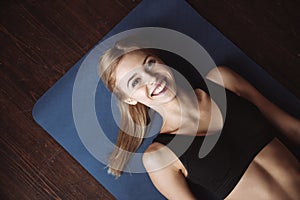 Top view of cherful woman athlete lying on the floor