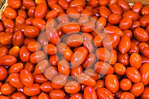 Cherry tomatoes on the counter of the vegetable market. Close-up and top view of fresh vegetables on store shelves.