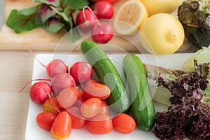 Top view cherry tomatoes They are placed in a tray with radishes, cucumbers, red oak lettuce.