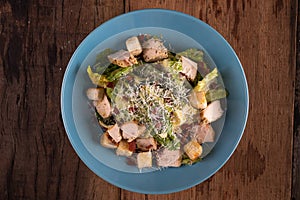 Top view of chicken Cesar salad with croutons and grated cheese