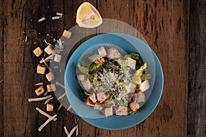 Top view of chicken Cesar salad with croutons and grated cheese