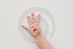 Top view of child hand showing four fingers as number four on the white background