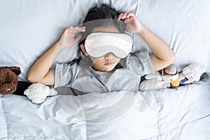 Top view child little asian girl blindfold sleeps in the bed