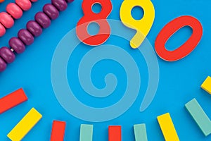 Top view on children`s educational games, frame from multicolored kids toys on blue paper background. Wooden bricks
