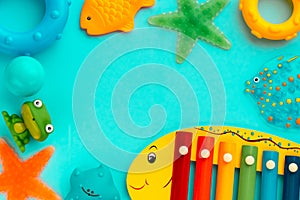 Top view on children`s educational and music games, frame from multicolored kids toys on light blue paper background. Circles,