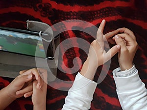 Top view of Children`s hands lying on the floor with digital tablet watching gaming videos online