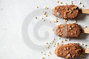 Top view of chocolate almond ice-cream on a wooden stick. Copy space