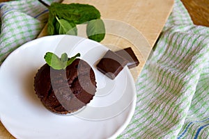 Top View of Chocolate Muffin with Mint Leaves on the Saucer in the Kitchen